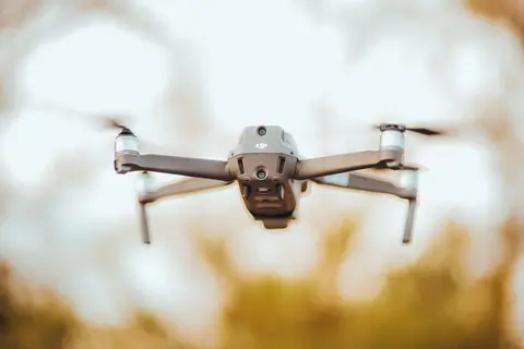 Close-up of a drone flying outdoors with a blurred background, showcasing technology in motion.