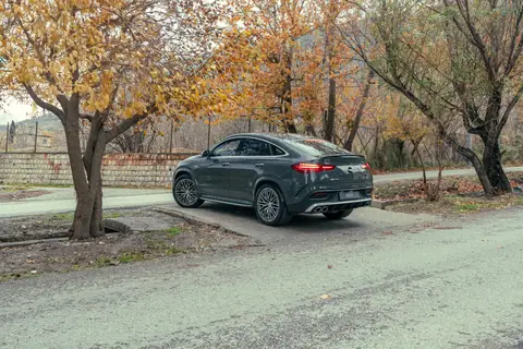 A sleek Mercedes-Benz displayed on a road amidst colorful fall foliage, showcasing elegance.