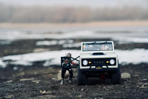 Close-up of a miniature toy car set in a snowy outdoor scene, highlighting detail and creativity.